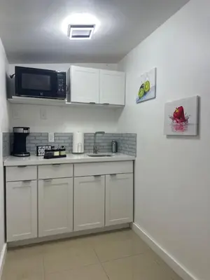 a kitchen with a sink and a microwave at Relaxing Studio Getaway w BBQ, Patio and Parking in Pembroke Pines