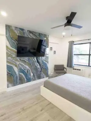 a bedroom with a bed and a tv on a wall at Beach Getaway in Hollywood