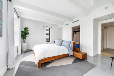 a white bedroom with a bed with blue pillows at The Netherland 2A I Ocean Drive I MIAMI BEACH OCEAN RENTAL in Miami Beach
