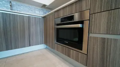 a kitchen with a microwave and a tv on a wall at Sleek New Brickell Condo With Free Parking - CS65 in Miami
