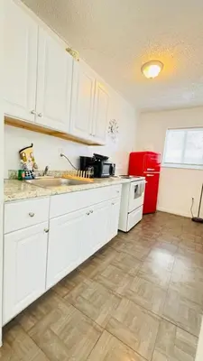a kitchen with white cabinets and a red refrigerator at Apt 202 Near Cruise Port, 5 Min to Downtown, 4 Min to Trains, 14Min to Airp in Miami