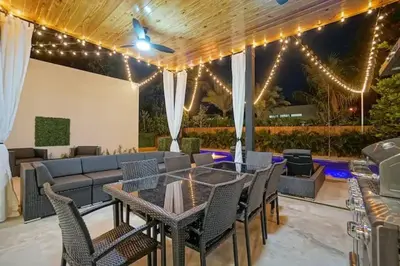 a patio with a couch and a table and chairs at NEW Bali Resort Style Villa with Vast Pool & Jacuzzi and Outdoor Grilling in Miami