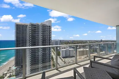 a balcony with a view of the beach and buildings at Seaside Splendor! Modern Condo with Ocean View in Hollywood