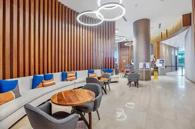 a lobby with a couch and tables and chairs at Seaside Splendor! Modern Condo with Ocean View in Hollywood