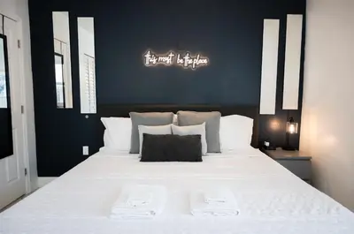 a bedroom with a large white bed with a black wall at Cozy Central Stay Airport, KingBed, Fenced Parking - Little Havana Near Airport, Wynwood, Calle 8 Brickell, Coral Gables and more in Miami