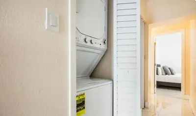 a white refrigerator in a room with a bedroom at Cozy Central Stay Airport, KingBed, Fenced Parking - Little Havana Near Airport, Wynwood, Calle 8 Brickell, Coral Gables and more in Miami