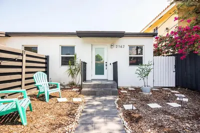 a house with two chairs in the front yard at Cozy Central Stay Airport, KingBed, Fenced Parking - Little Havana Near Airport, Wynwood, Calle 8 Brickell, Coral Gables and more in Miami