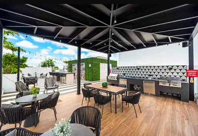 a patio with tables and chairs and a grill at The Logan I in Miami