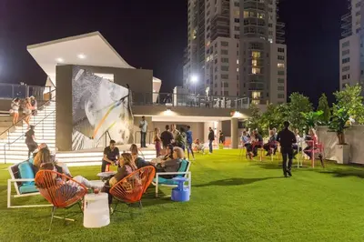 a group of people sitting in chairs in a park at night at The Bayfront VII in Miami