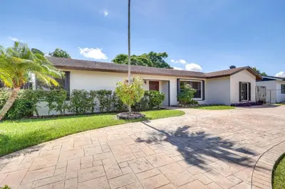 a house with a palm tree in the driveway at Pet-Friendly Home with Yard about 3 Mi to Zoo Miami! in Cutler Ridge