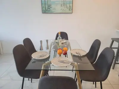 a dining table and chairs with oranges on it at Modern 1 BR Condo, Steps from Beach, Free Parking! in Sunny Isles Beach