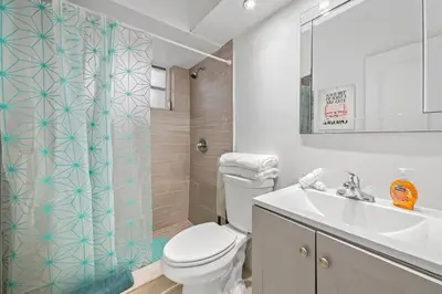 a bathroom with a toilet and a sink and a shower at Escape 2 Beach, Ocean Dr Deco Apt with 2 Queen beds in Miami Beach