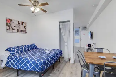 a room with a bed and a table and a ceiling fan at Easy Ocean Dr Beach, 2 Queenbeds in Miami Beach