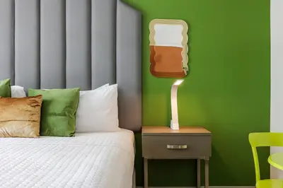 a bedroom with a bed and a green wall at Claremont Hotel in Miami Beach