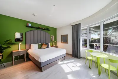 a bedroom with a bed and a green wall at Claremont Hotel in Miami Beach