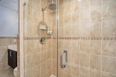 a shower with a glass door in a bathroom at Luxury Tropical Living , 4BR w Backyard Pool Oasis in Hialeah