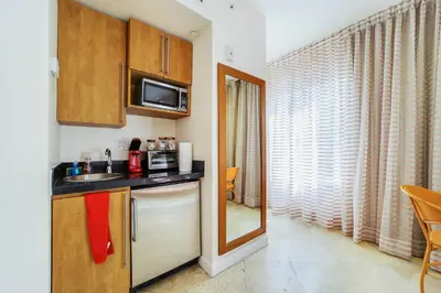 a small kitchen with a sink and a microwave at Casa Victoria Orchid Hotel in Miami Beach