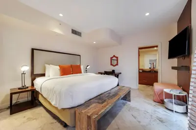 a bedroom with a large bed and a television at Casa Victoria Orchid Hotel in Miami Beach