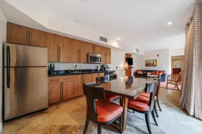 a kitchen with a table and a refrigerator at Casa Victoria Orchid Hotel in Miami Beach