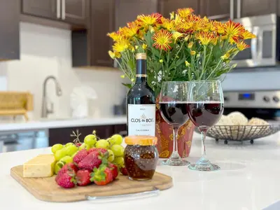 a bottle of wine next to two glasses of wine at Zen Den - Heated Pool, Work Friendly, Near Beach in Fort Lauderdale