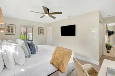 a bedroom with a white bed with a ceiling fan at Zen Den - Heated Pool, Work Friendly, Near Beach in Fort Lauderdale