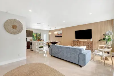 a living room with a blue couch and a kitchen at Zen Den - Heated Pool, Work Friendly, Near Beach in Fort Lauderdale