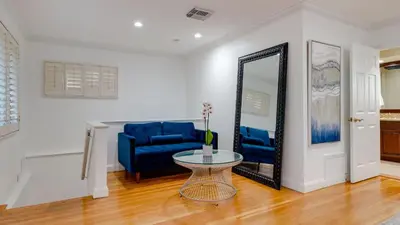 a living room with a blue couch and a mirror at 5mins to Beach • Pool Hot Tub • Billiards Coral Ridge Getaway by AvantStay in Fort Lauderdale