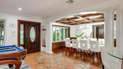 a dining room with a table and white chairs at 5mins to Beach • Pool Hot Tub • Billiards Coral Ridge Getaway by AvantStay in Fort Lauderdale