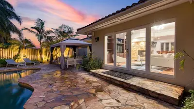 a home with a swimming pool and a house at 5mins to Beach • Pool Hot Tub • Billiards Coral Ridge Getaway by AvantStay in Fort Lauderdale