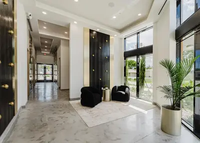 a hallway with black chairs and a potted plant at Modern 2BR, Family-Friendly in FLL, Near Beach! in Fort Lauderdale