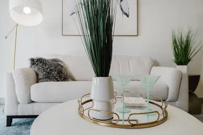 a living room with a table with a vase and glasses at Prime 2BR by FLL Airport & Dania Beach Attractions in Fort Lauderdale