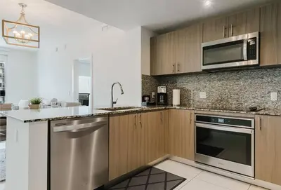 a kitchen with stainless steel appliances and wooden cabinets at Wonderful 1 bedroom Apartment in Downtown Doral in Miami