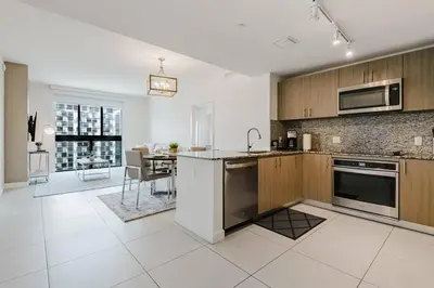 a kitchen with stainless steel appliances and a dining room at Wonderful 1 bedroom Apartment in Downtown Doral in Miami