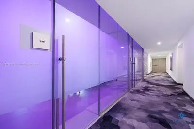 an empty hallway with purple walls and glass doors at Best Stay Gym Bar and Spa in Miami