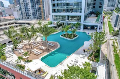 an aerial view of a resort pool with palm trees at Modern Apartment 2BR-2BTH- Pool & Gym in Miami