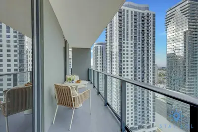 a balcony with a table and chairs and tall buildings at Modern Apartment 2BR-2BTH- Pool & Gym in Miami