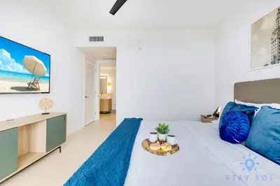 a bedroom with a large bed with blue pillows at Spectacular Apartment with Pool & Gym in Miami