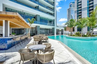 a swimming pool with tables and chairs next to a building at Spectacular Apartment with Pool & Gym in Miami