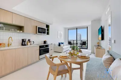 a kitchen and living room with a table and chairs at Oasis Apartment 1 Bedroom with Pool & Gym in Miami