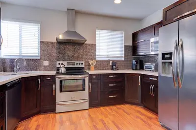 a kitchen with wooden cabinets and stainless steel appliances at Luxury Home in Brickell Miami, 5 min to the Beach! in Miami