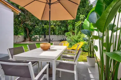 a white table and chairs with an umbrella at Luxury Home in Brickell Miami, 5 min to the Beach! in Miami