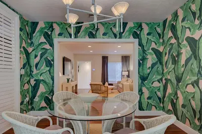 a dining room with a glass table and green leafy wall at Luxury Home in Brickell Miami, 5 min to the Beach! in Miami