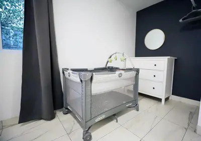 a shopping cart in a room with a dresser at 3 Minute Walk to Miami Beach Family and Pet Friendly Apartment in Miami Beach