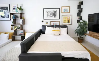 a black couch in a living room with a tv at 3 Minute Walk to Miami Beach Family and Pet Friendly Apartment in Miami Beach