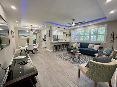 a living room with a blue couch and a table at 2Bdrm 1Bath Newly Renovated Condo - Walk to the Beach! in Fort Lauderdale