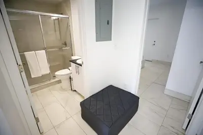 a bathroom with a shower and a toilet and a stool at Family Pet Friendly Apartment 3 Minute Walk to Miami Beach in Miami Beach