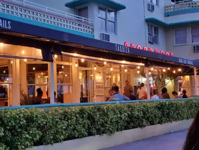 people sitting outside of a restaurant at night at Family Pet Friendly Apartment 3 Minute Walk to Miami Beach in Miami Beach