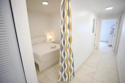 a hallway with a room with a bed and a tie at Family Friendly Condo Steps to Miami Beach with Free Parking in Miami Beach