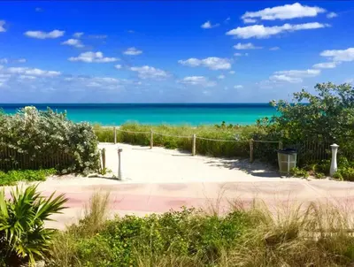 a path to the beach with the ocean in the background at Family Friendly Condo Steps to Miami Beach with Free Parking in Miami Beach