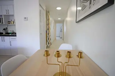 a dining room with a wooden table and white chairs at Family Friendly Condo Steps to Miami Beach with Free Parking in Miami Beach